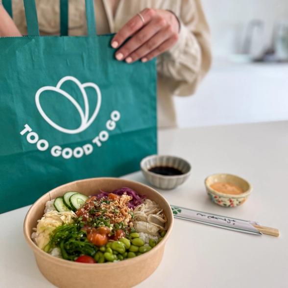 Poke bowl, condiments and chopsticks on a counter