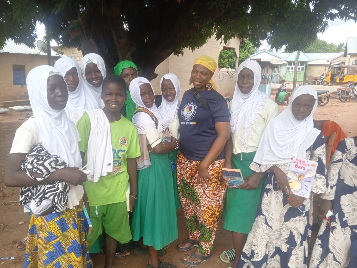 KAPAW staff presenting book donations to children