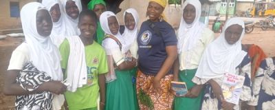 KAPAW staff presenting book donations to children