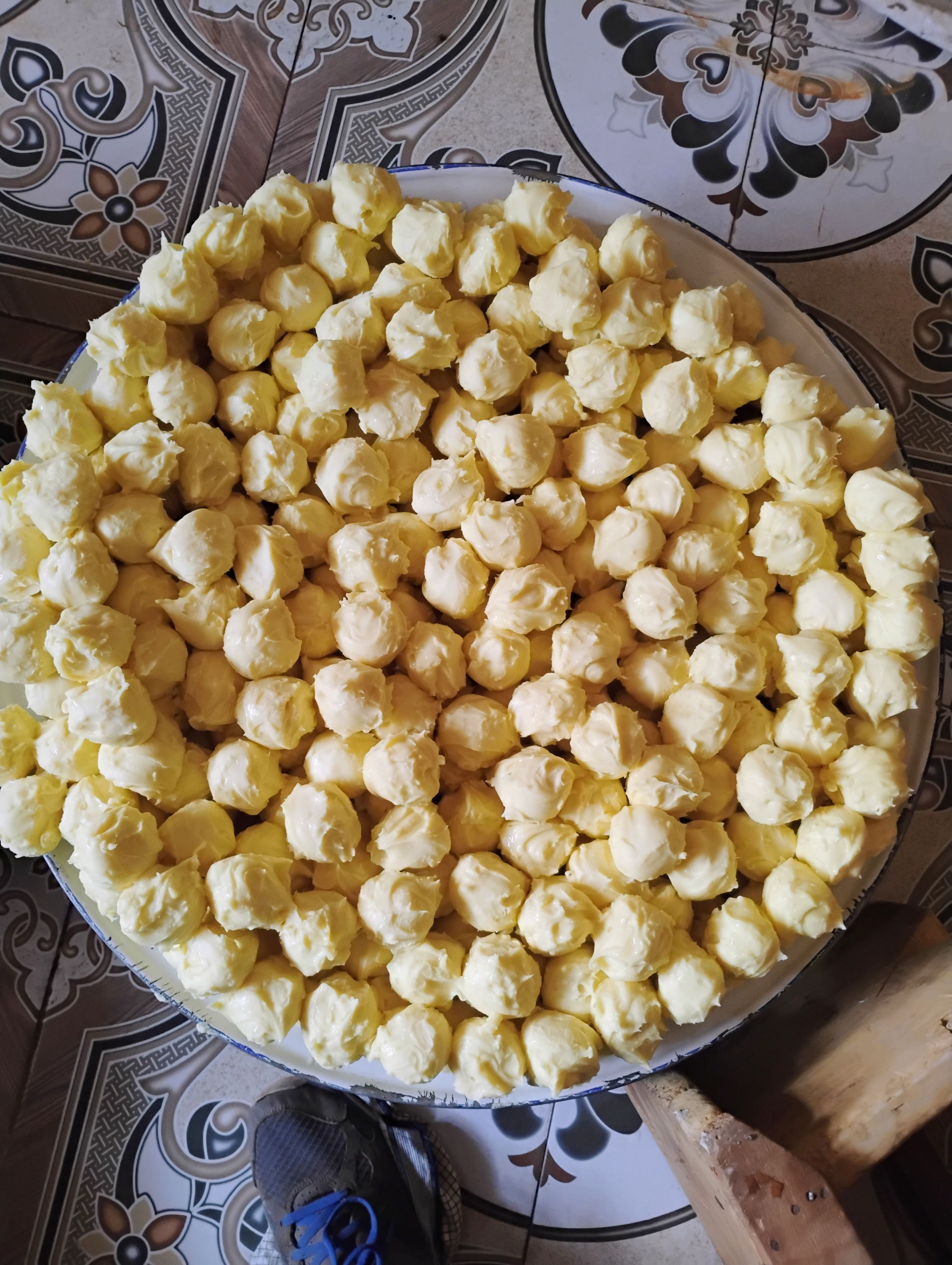 Freshly made shea butter balls arranged in a large bowl