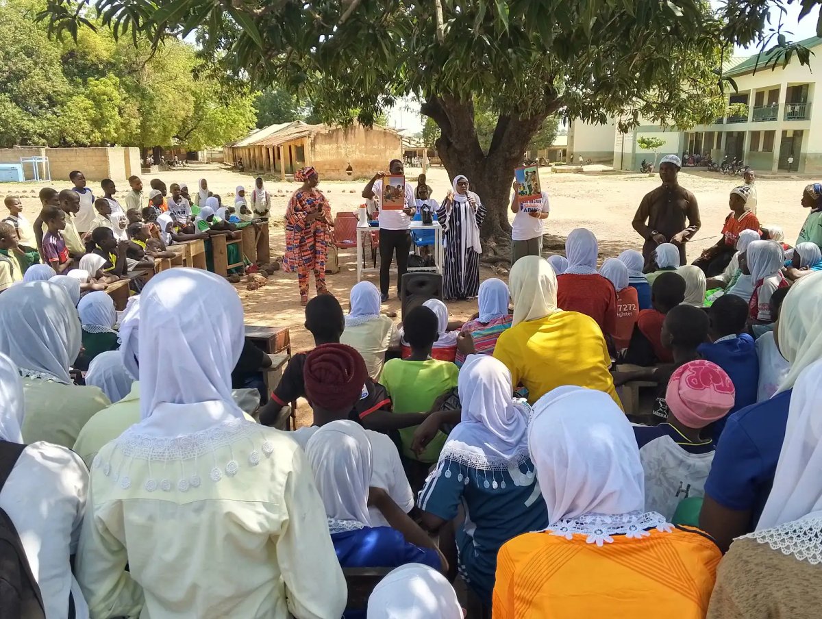 Large outdoor substance abuse awareness dialogue session with speakers and a crowd of students