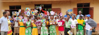 Students holding donated books at a KAPAW book donation event
