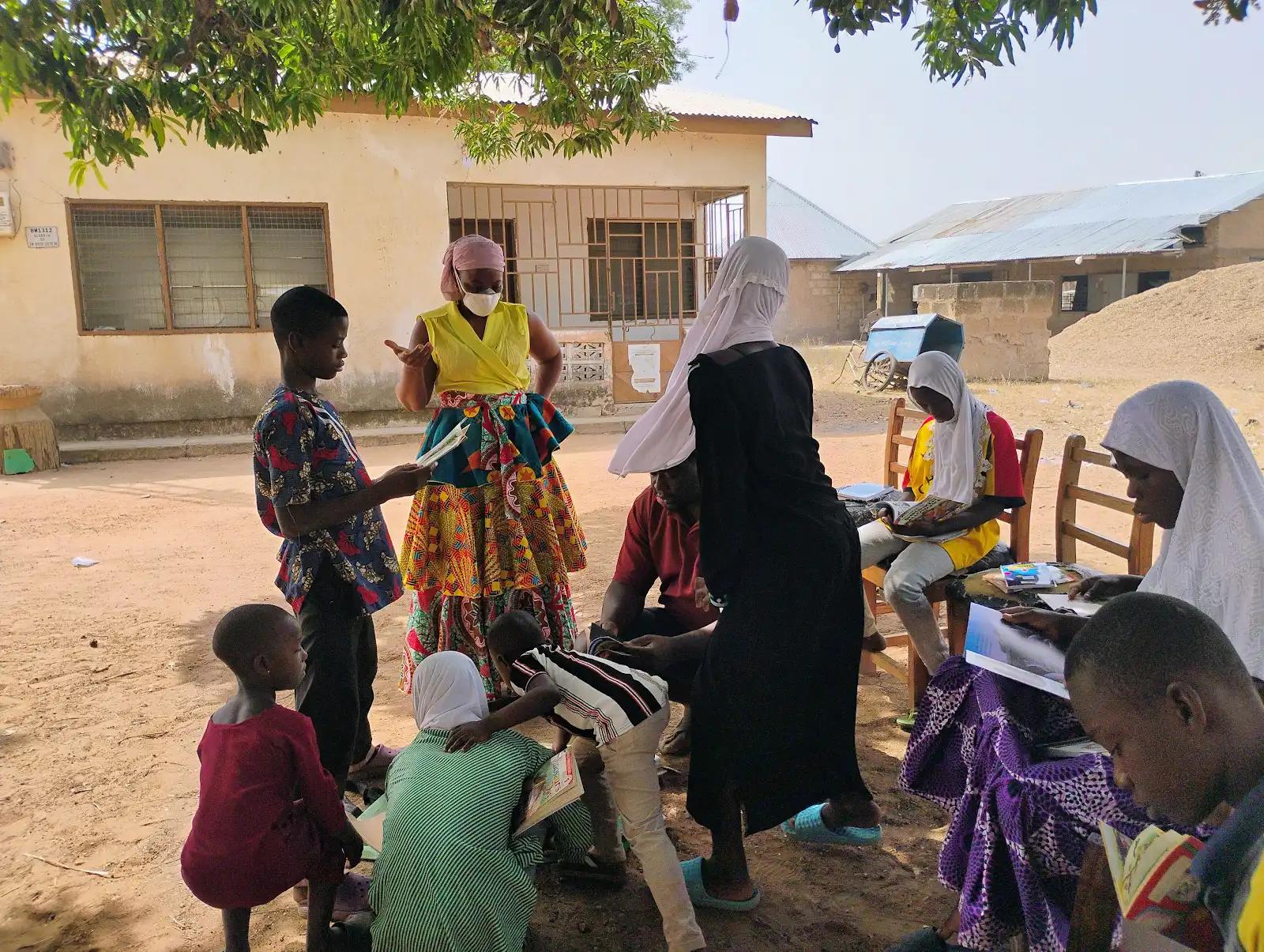 Facilitator working with children in a safe space outdoor reading session