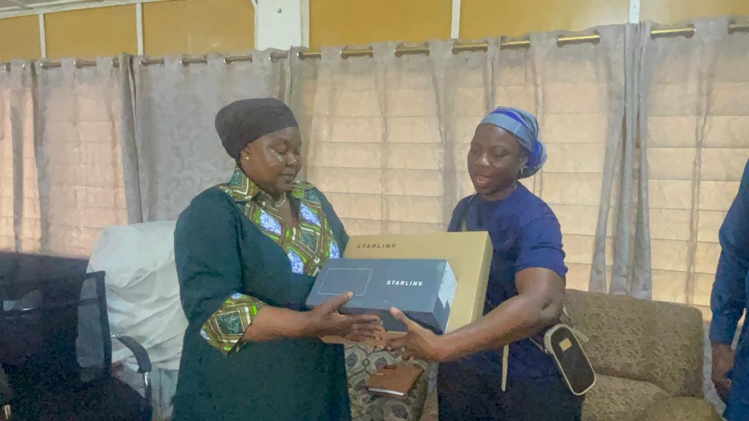 Two people completing a Starlink equipment handover, Upper West Region