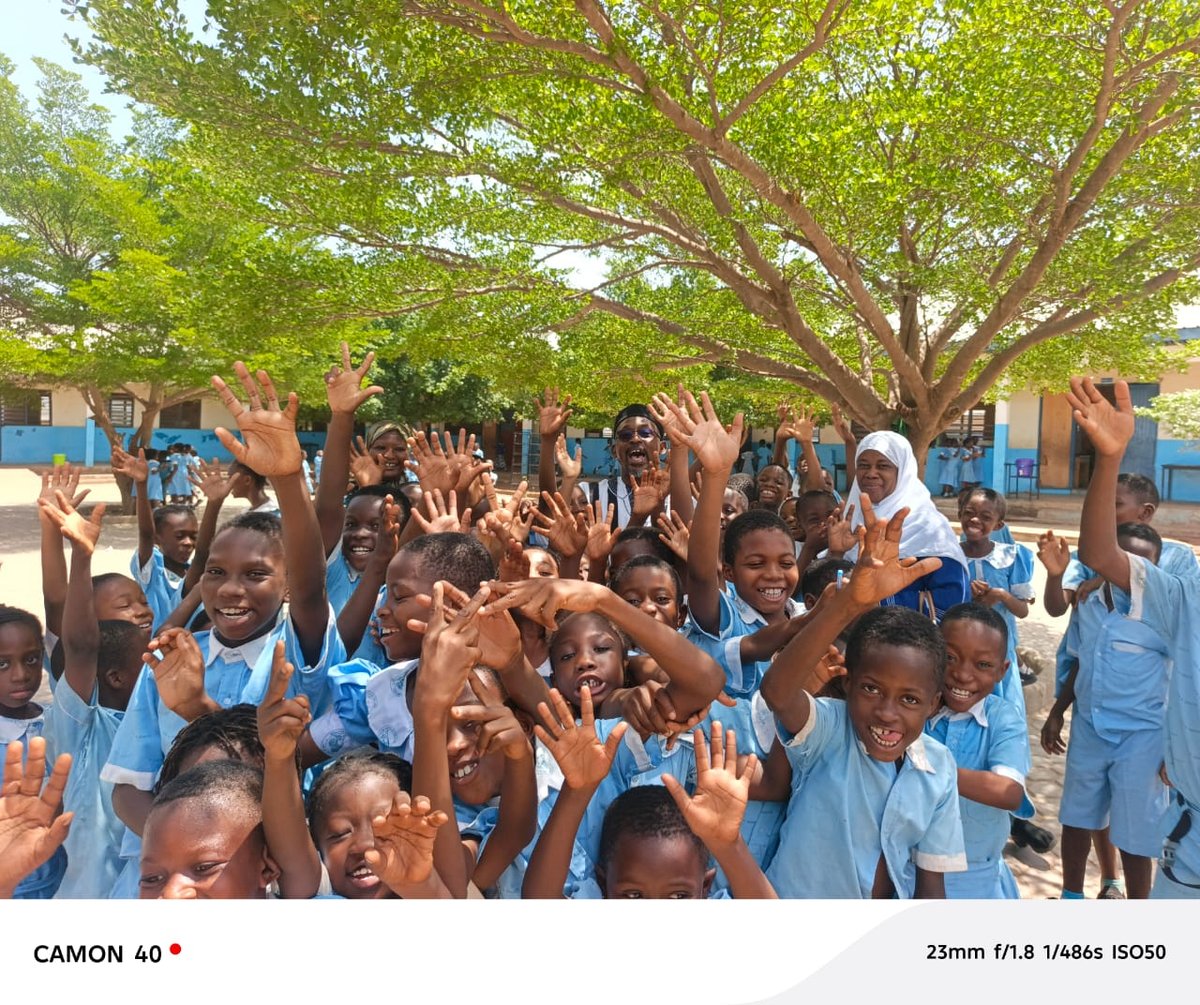 Children joyfully raising hands at a traditional literacy and cultural gathering