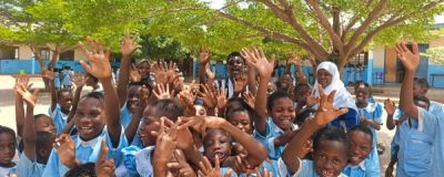 Children joyfully raising hands at a KAPAW community gathering