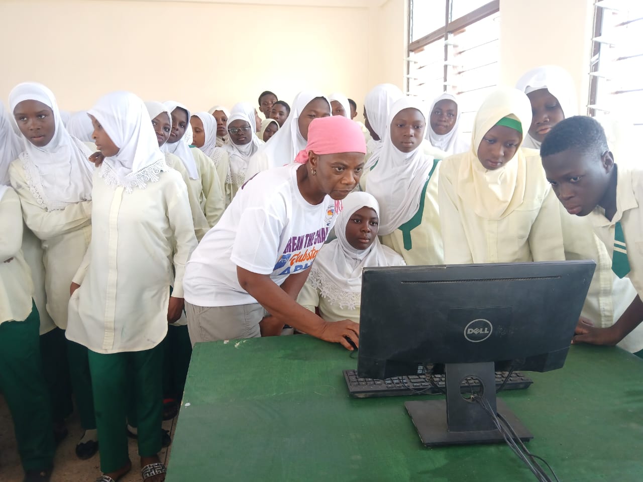 Students crowded around a Dell computer during a digital learning session