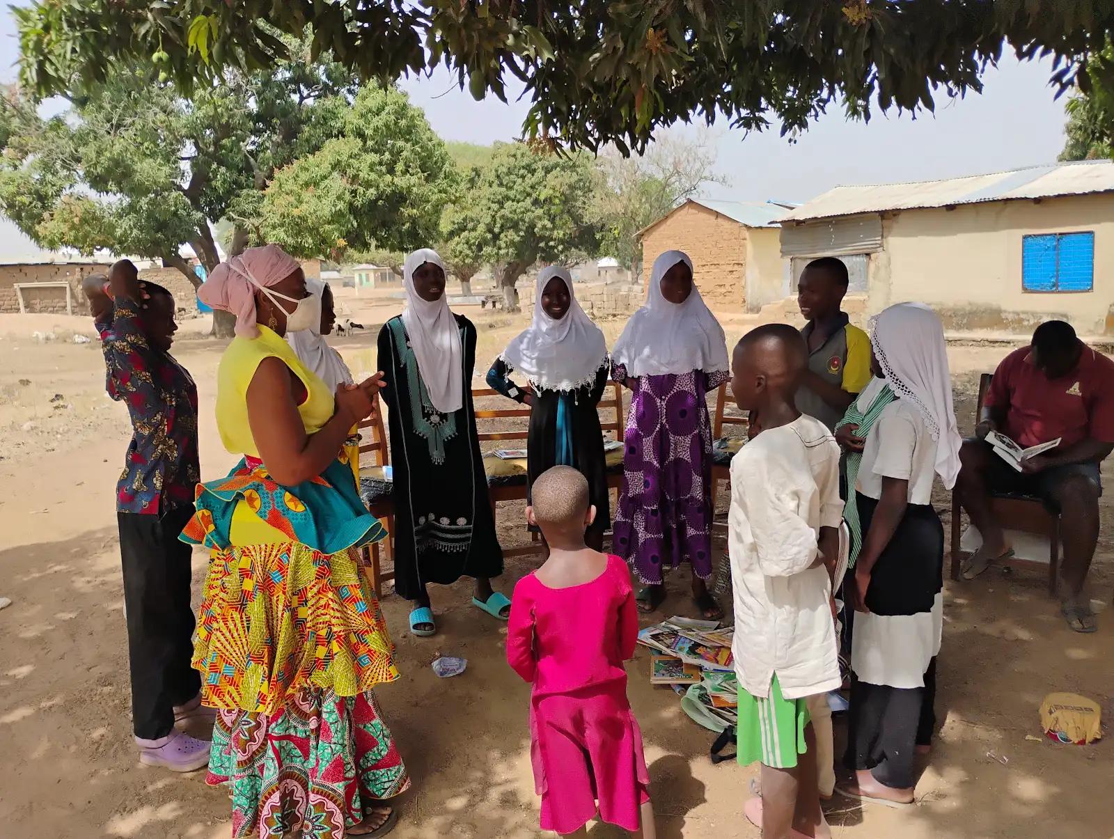 Leadership and safe space club circle activity with facilitator and children outdoors