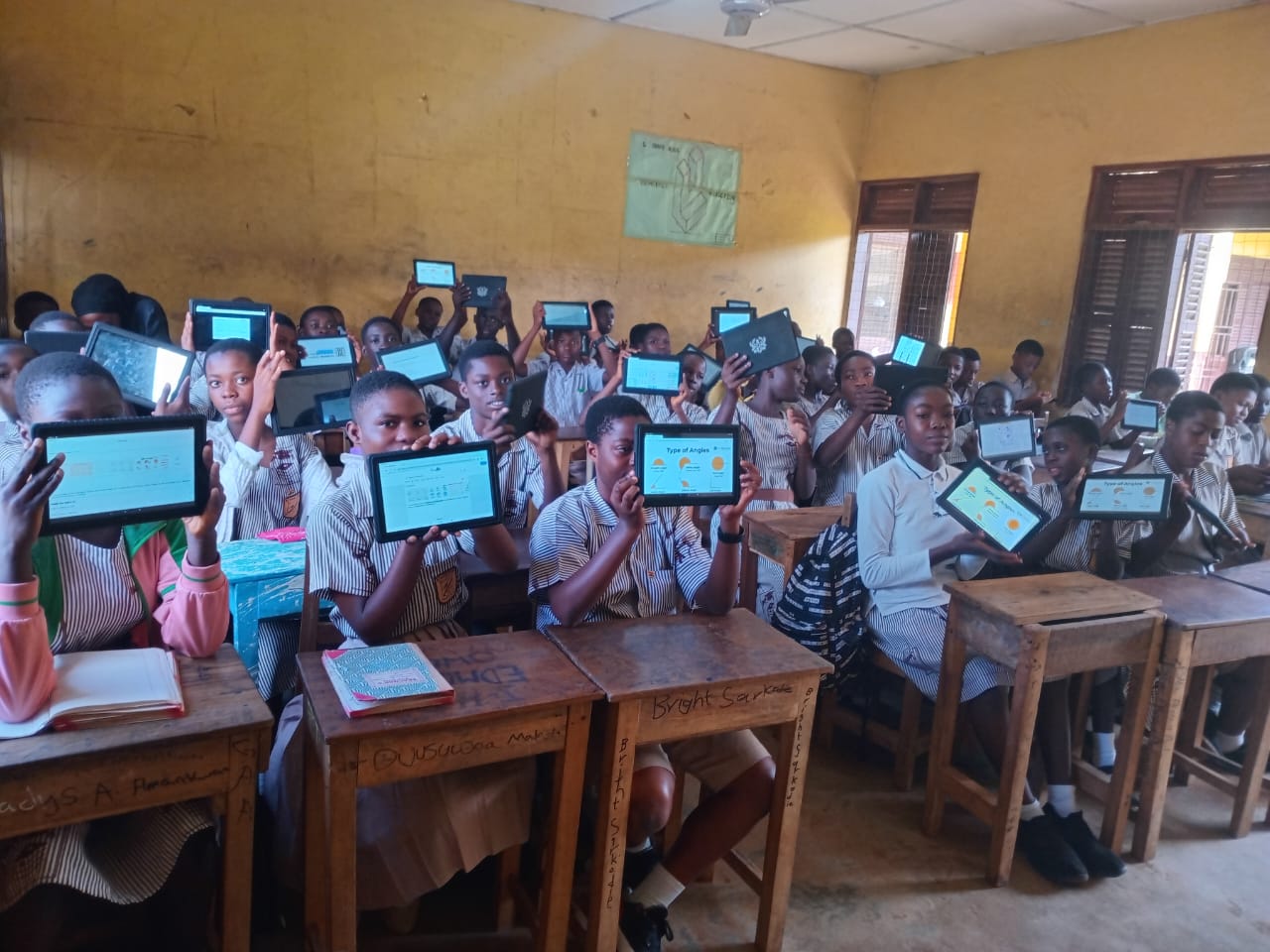 Students holding up tablets displaying maths learning content