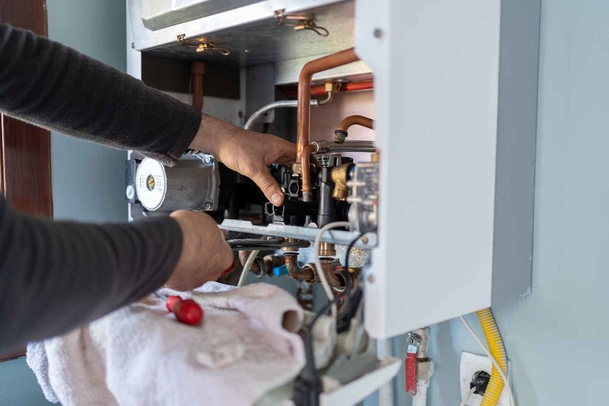 Engineer fixing a boiler in a London home during routine servicing.