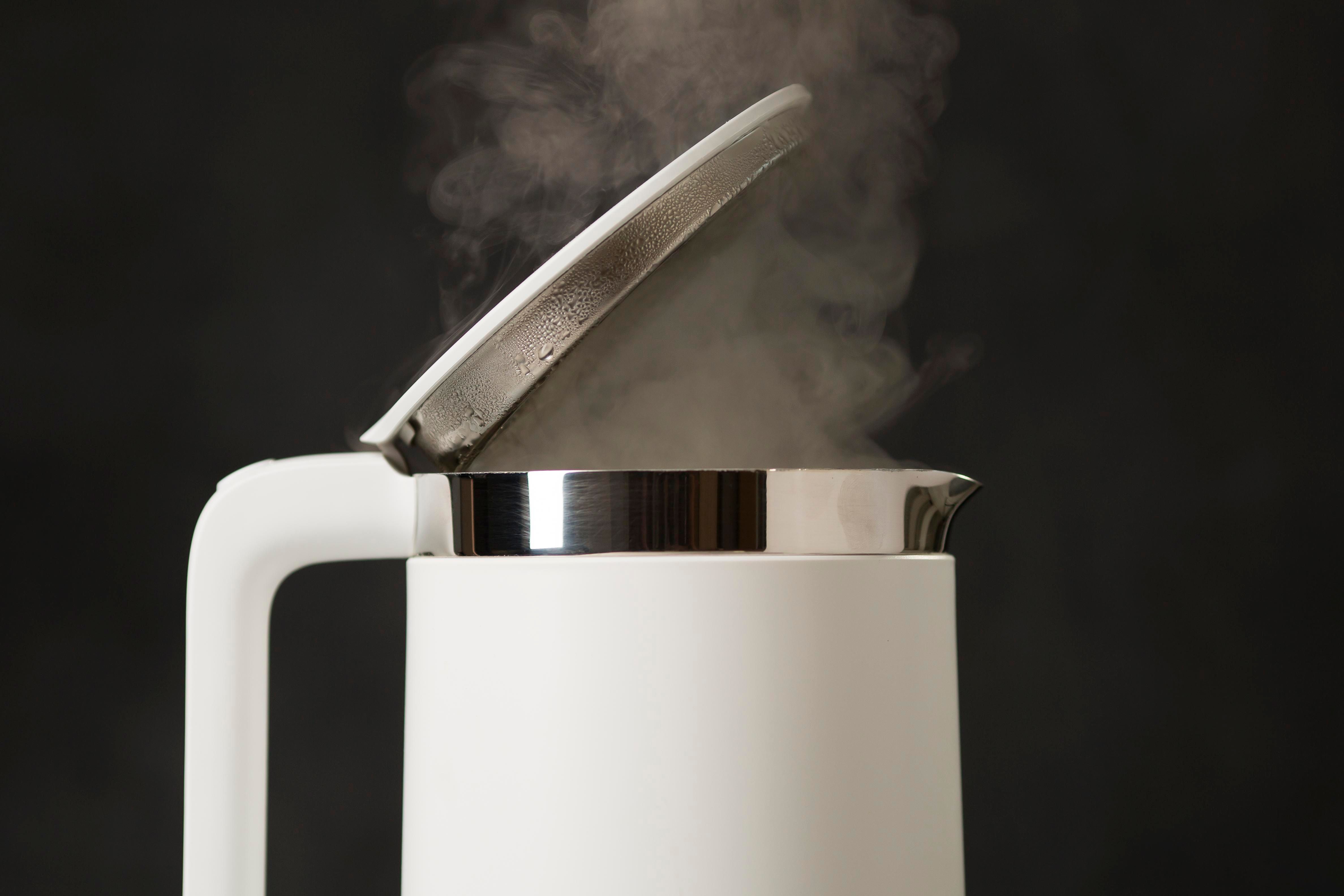 Pouring boiling water into a sink to clear a blockage