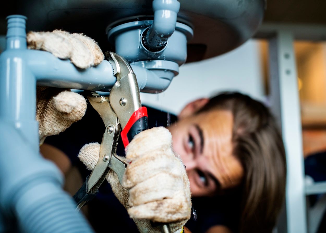 Homeowner in London addressing a plumbing emergency before professional help arrives.