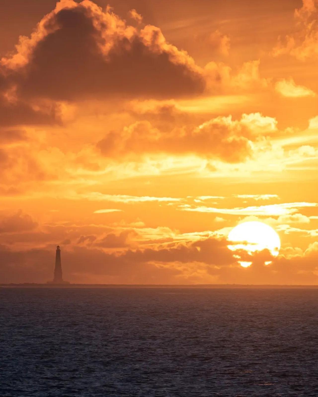 Silhouette du phare de Cordouan devant un ciel orangé