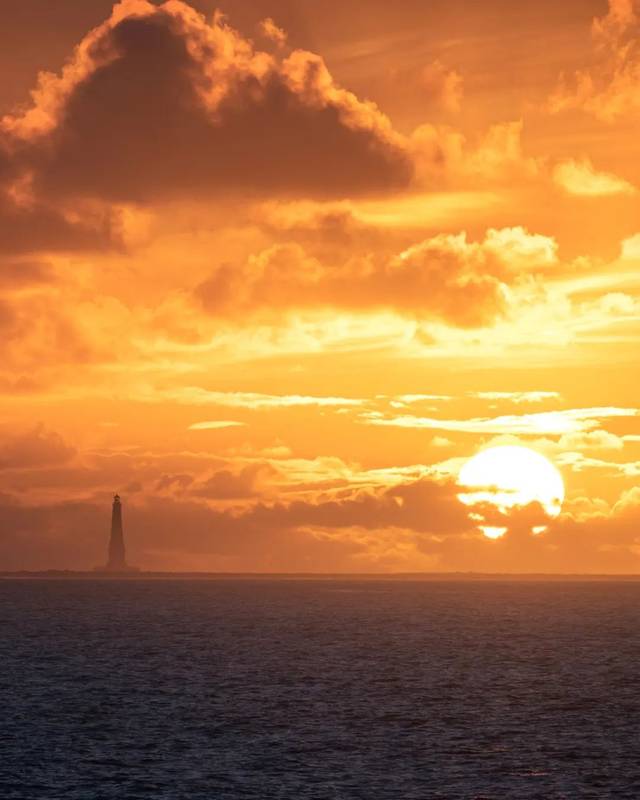Silhouette du phare de Cordouan devant un ciel orangé