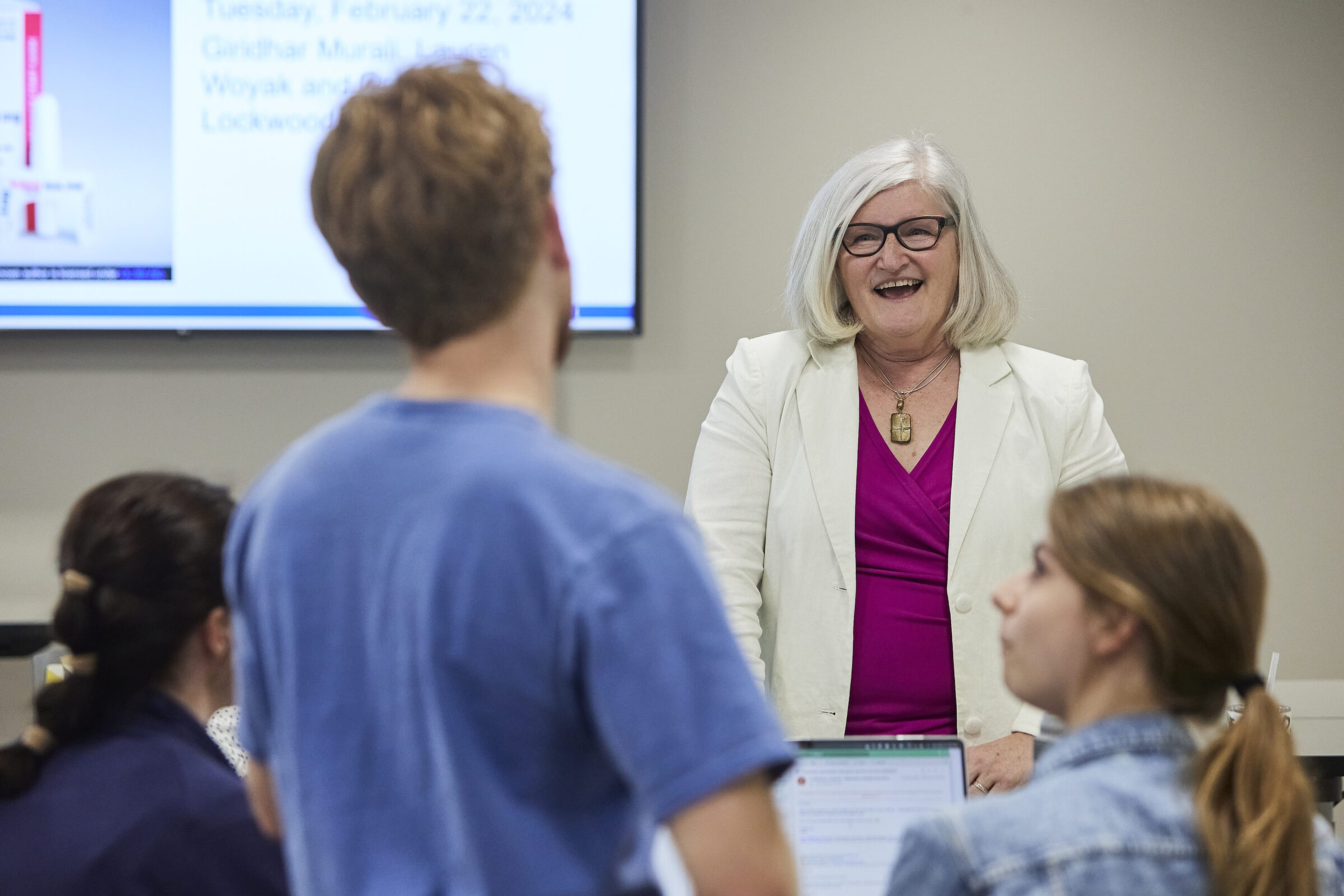 An instructor laughing with medical students around a seminar table in Wausau.