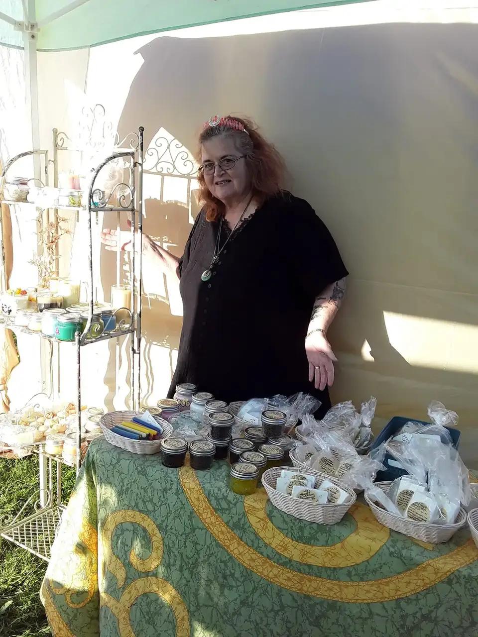 Rev. Berta Kay at her outdoor fair table with sunflowers