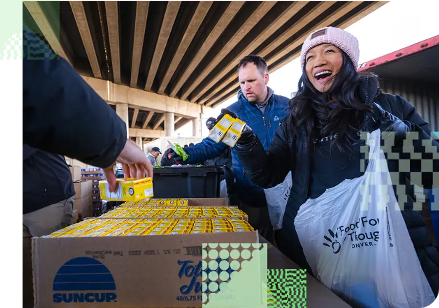 A woman smiles while she fills a donation bag with food