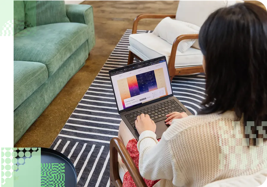 A woman working on her colorful website on a couch.