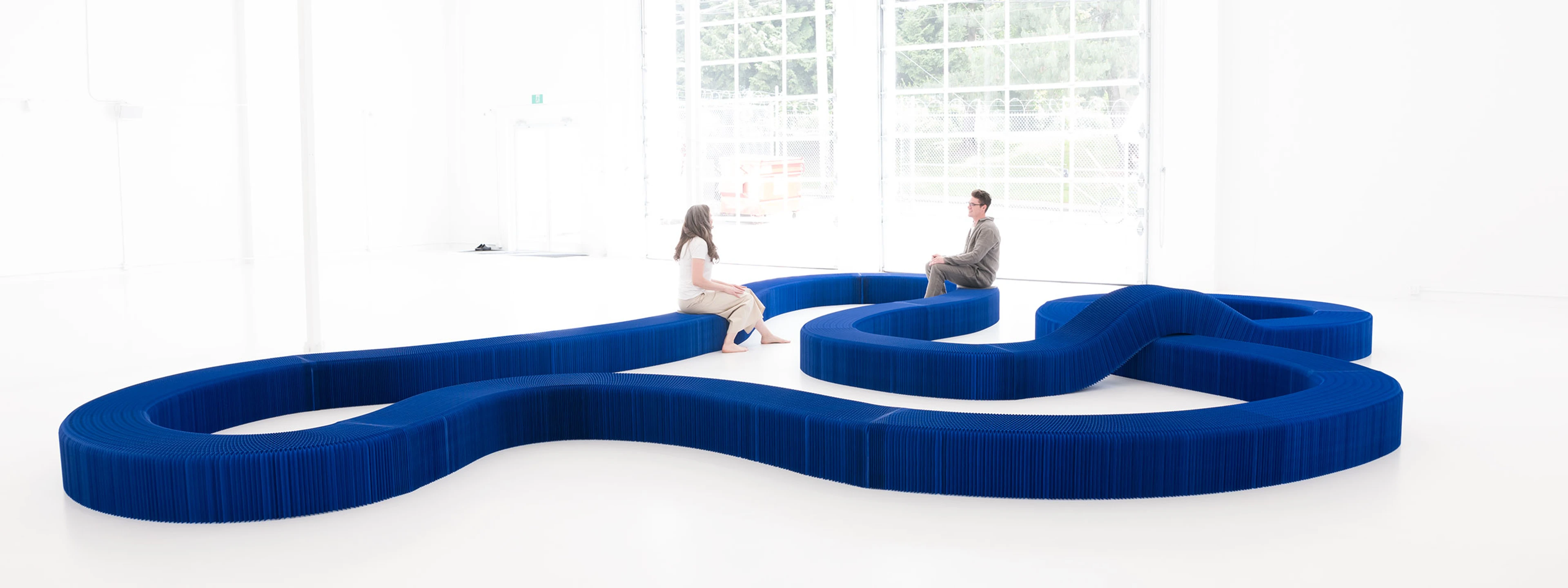 a serpentine bench made from indigo softseating fanning stool + bench
