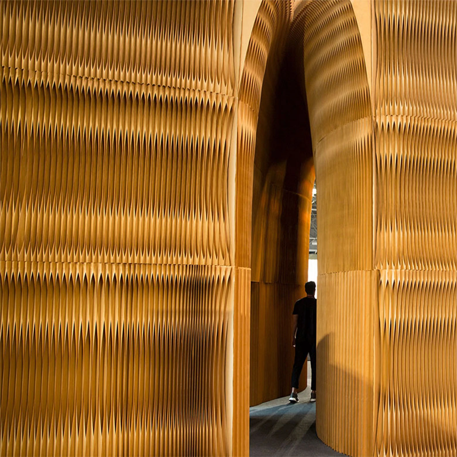 A massive parabolic vault made from stacked paper softwalls.