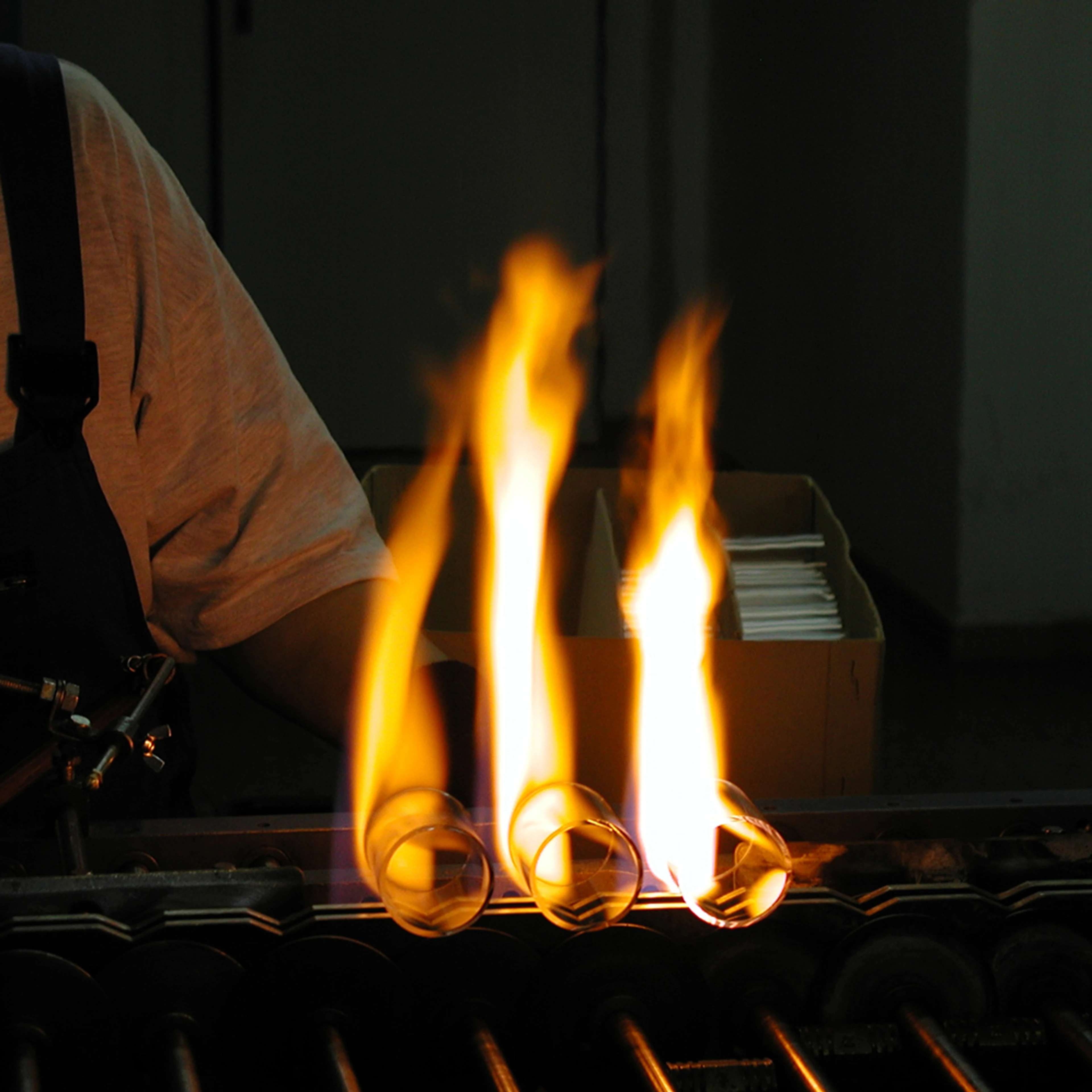 Flame leaps from three glass cylinders being crafted in the Czech Republic.