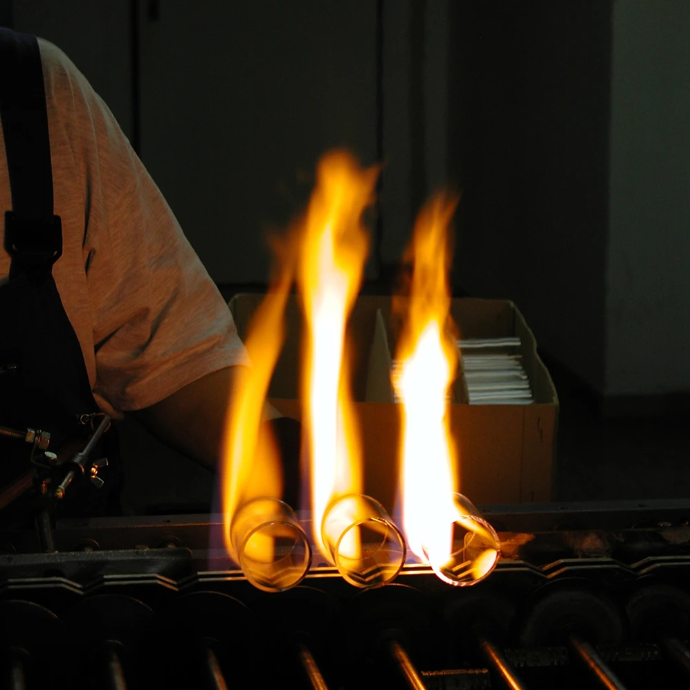 Flame leaps from three glass cylinders being crafted in the Czech Republic.