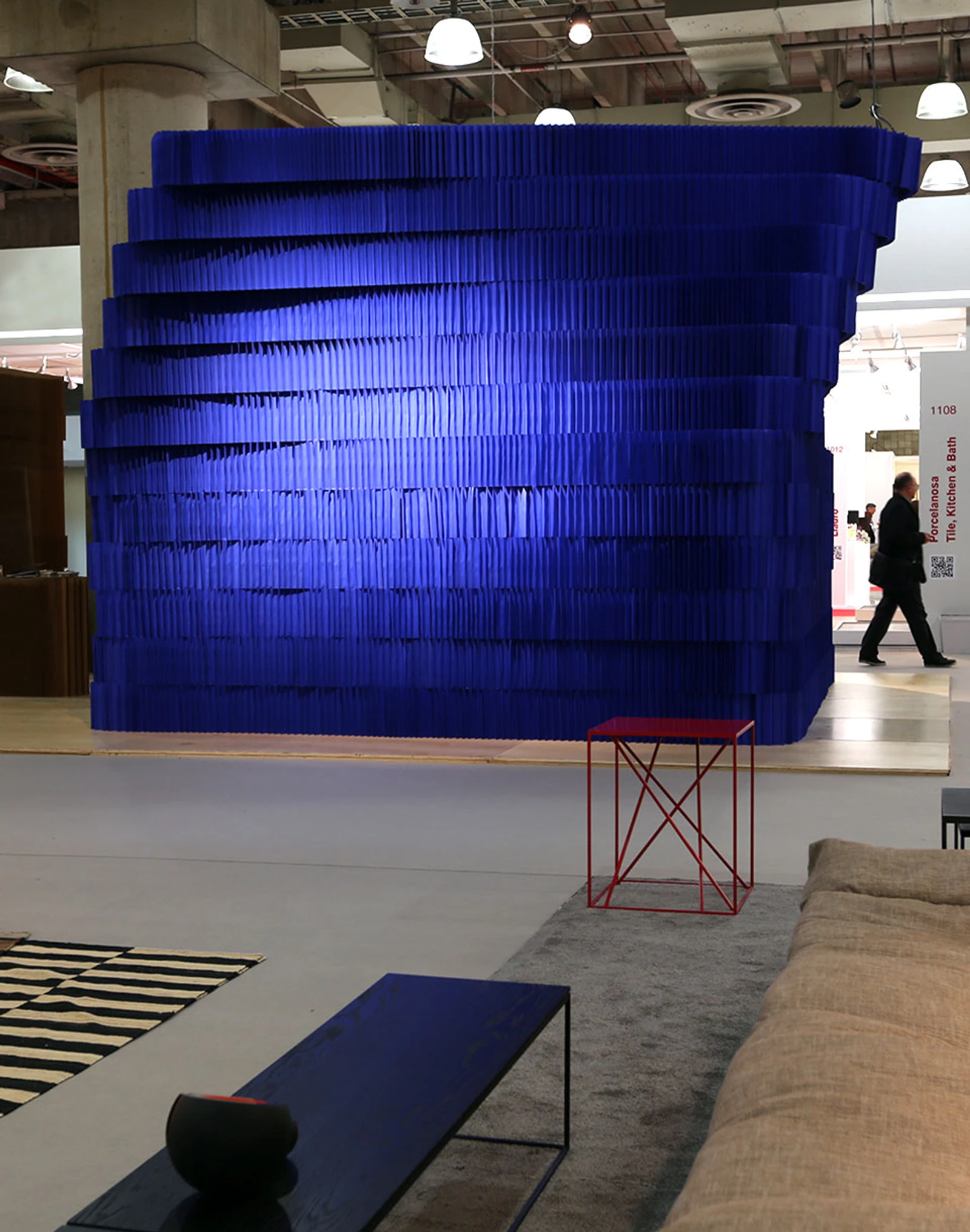 A stack of flexible paper building blocks create a torqued room at ICFF - acoustic design