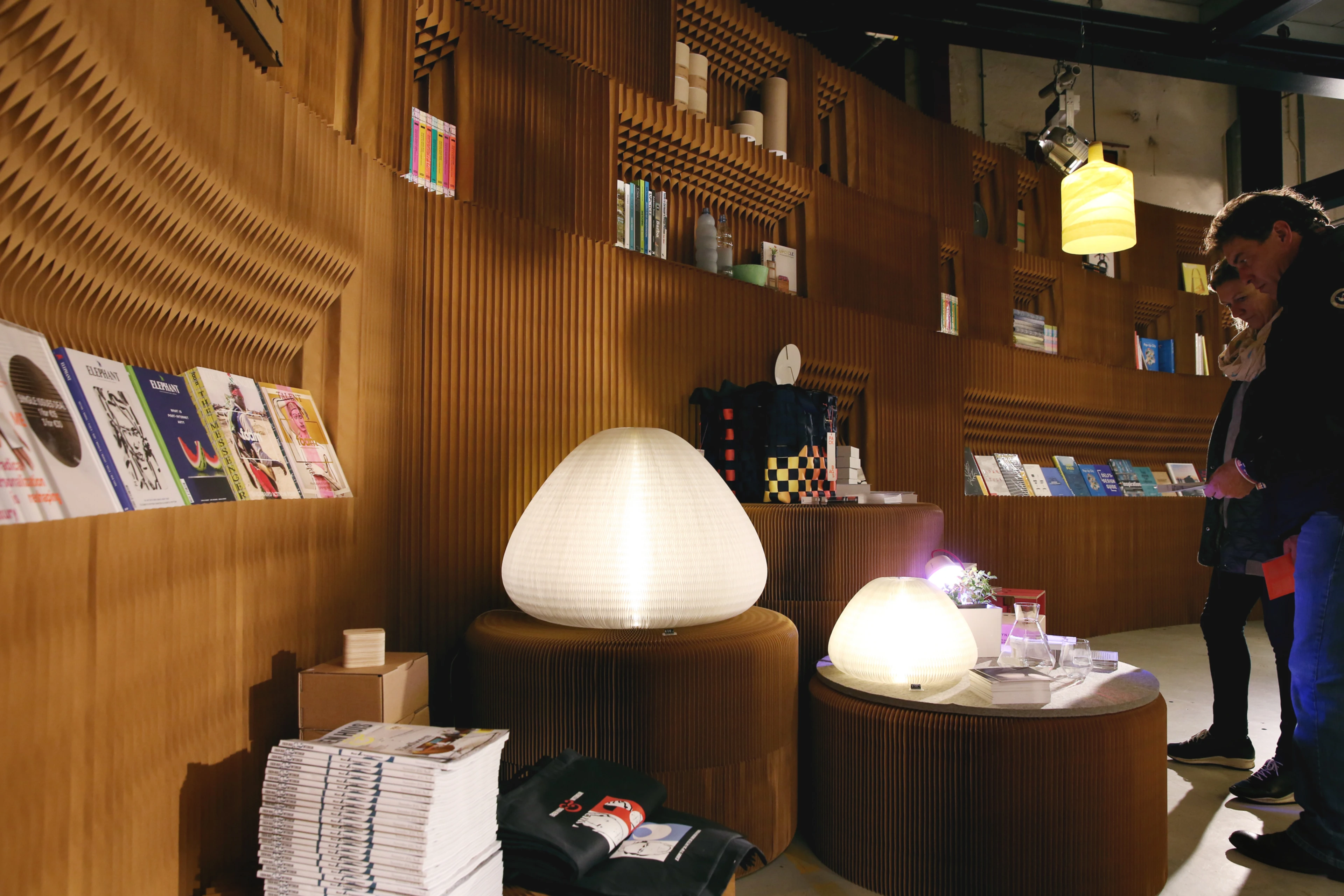 expandable paper seating and furniture by molo - molo's various table and seating elements easily double as surfaces for product display, as in this booth for FRAME Magazine