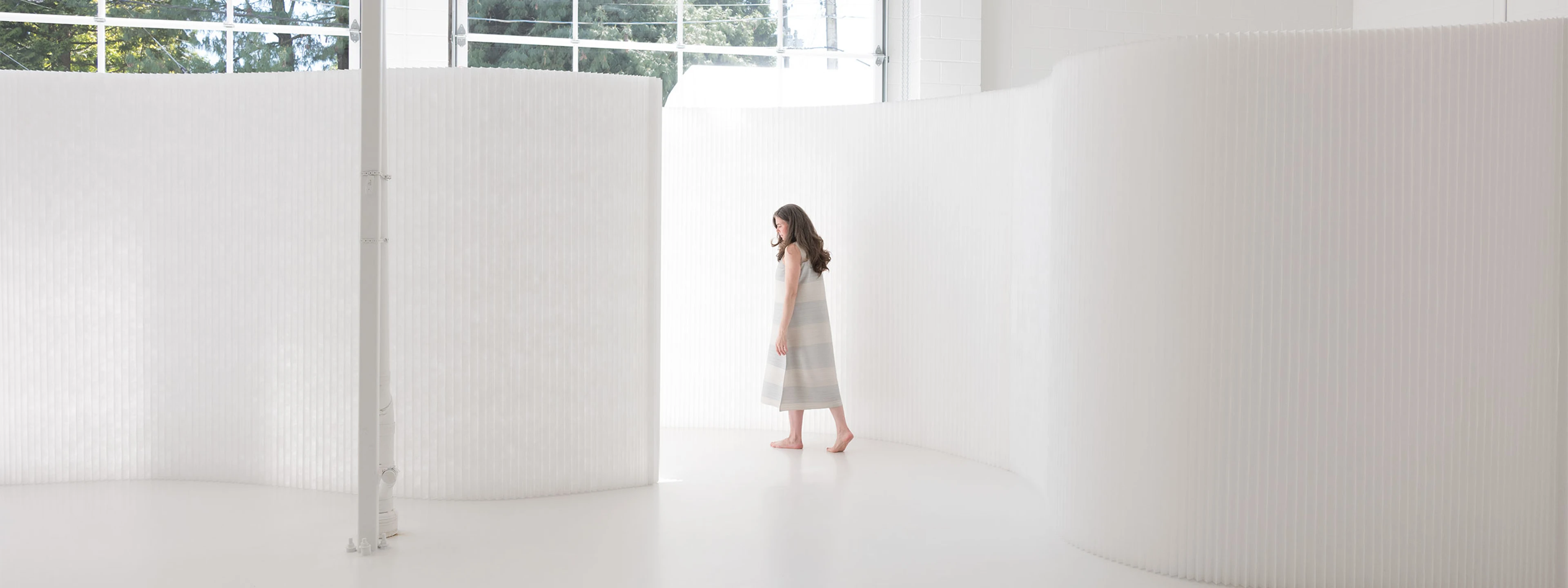 A translucent interior partition, textile softwall is a flexible folding wall that can be adjusted to any shape to create a sculptural backdrop or divide space.
