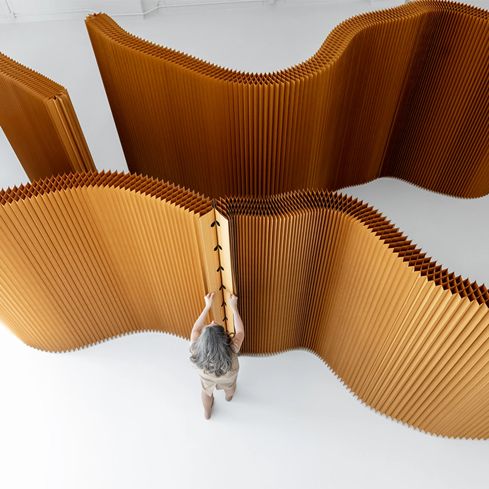 woman attaches two softwall end panels by their magnetic connectors
