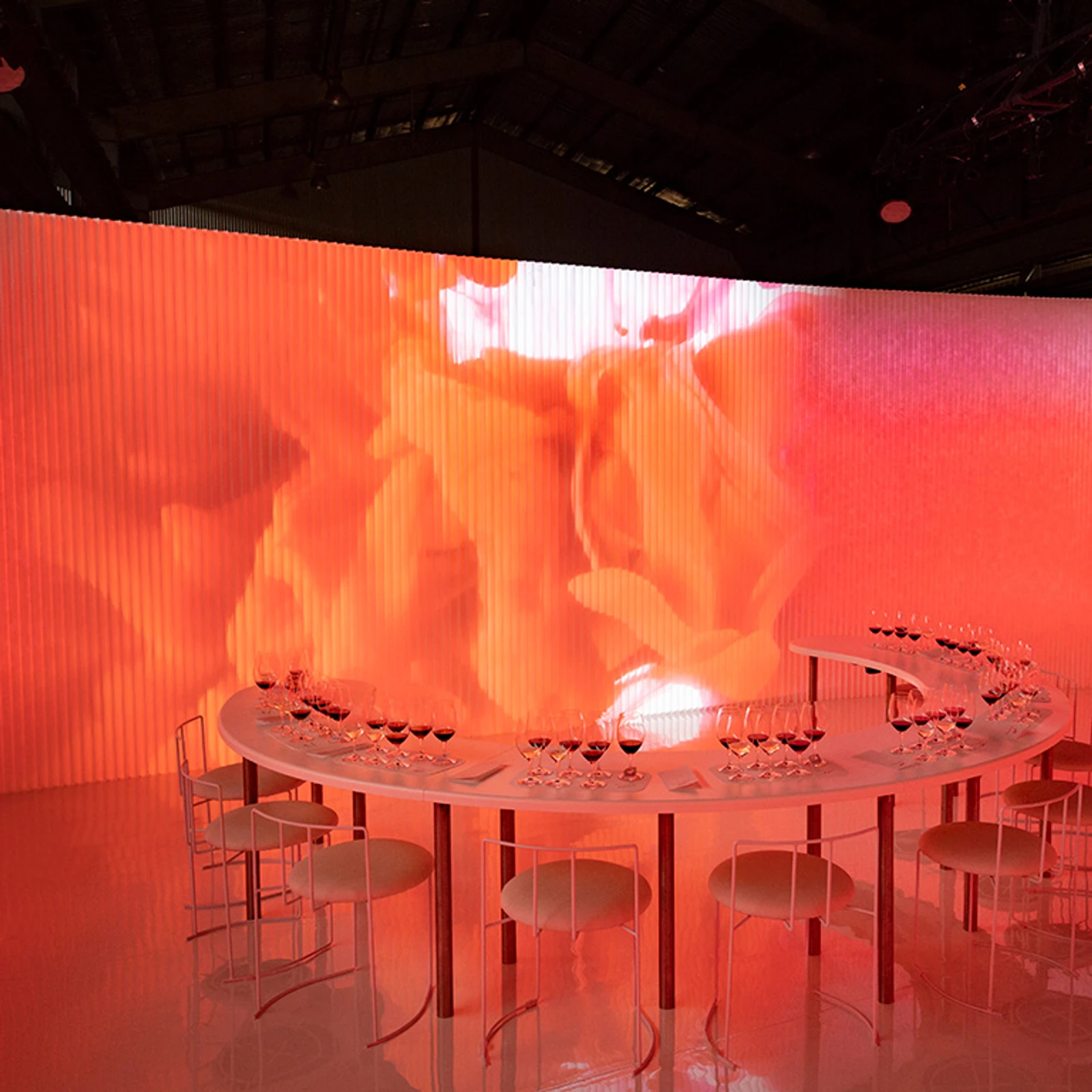 white textile softwall with coloured light projections | illuminated orange and pink wall