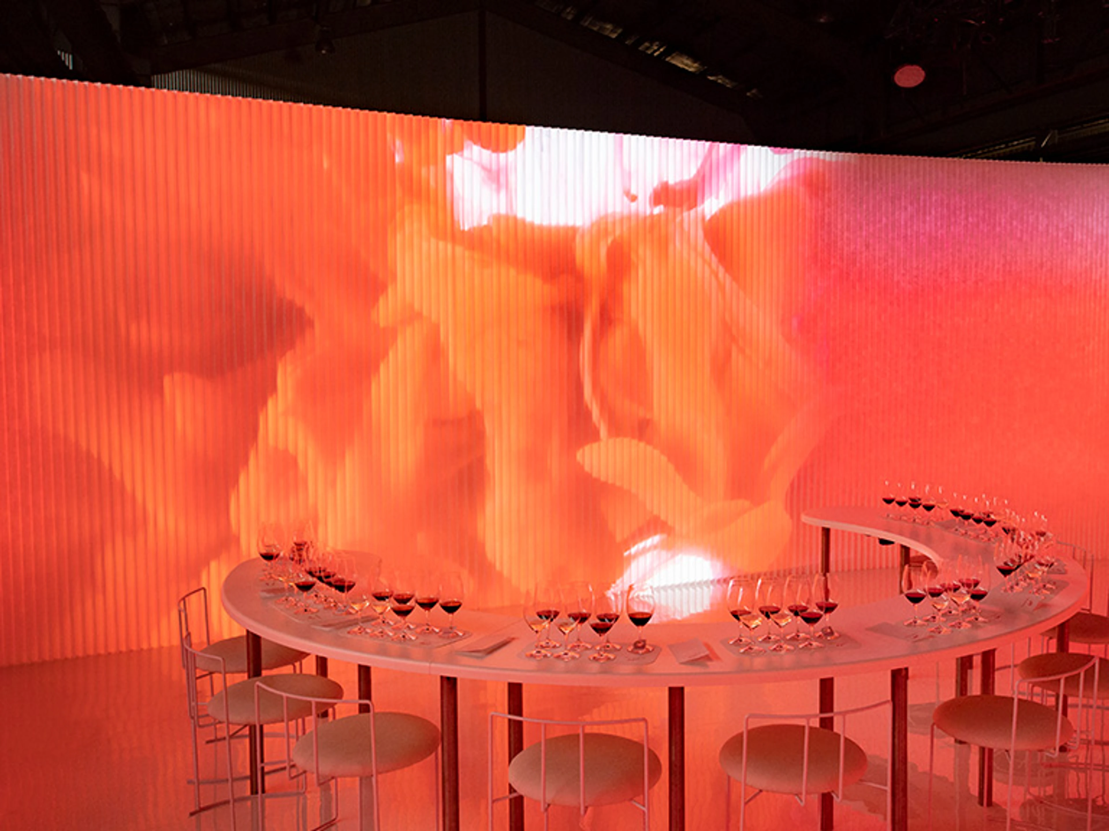 white textile softwall with coloured light projections | illuminated orange and pink wall