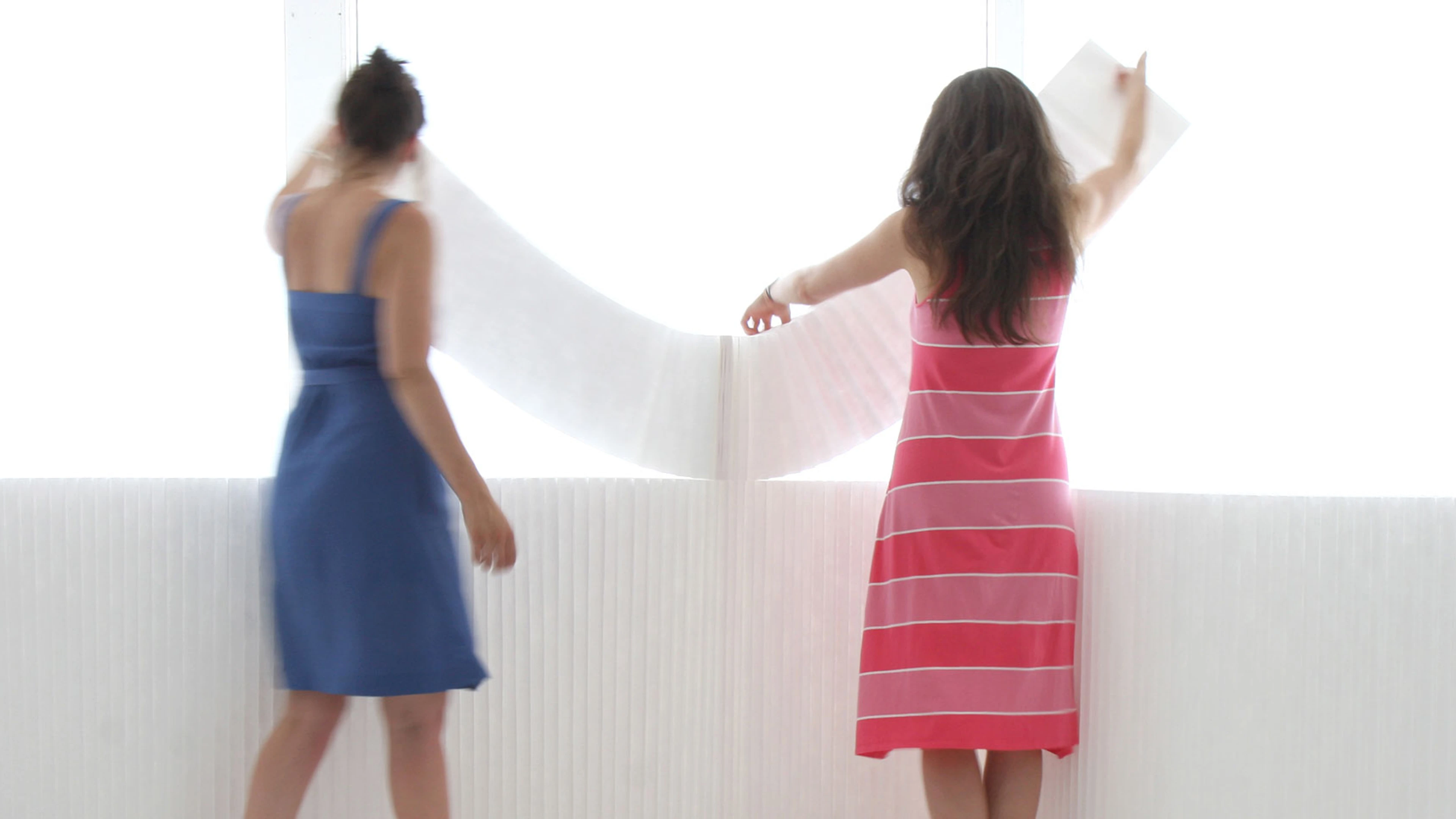 two women arrange white textile softblocks