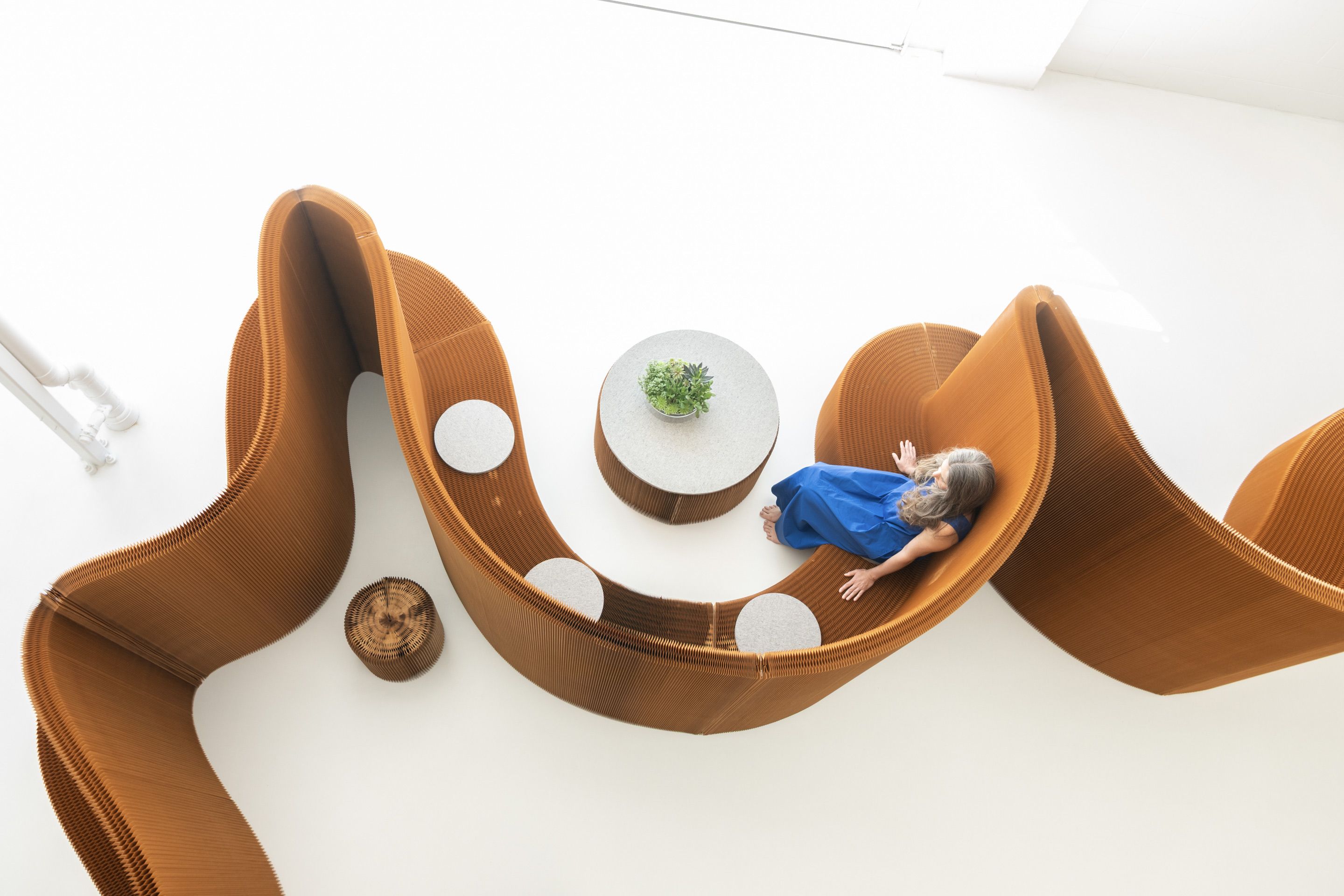 Pair softseating with benchwall as low tables, unifying space through flexible function, common materiality, and aesthetics.