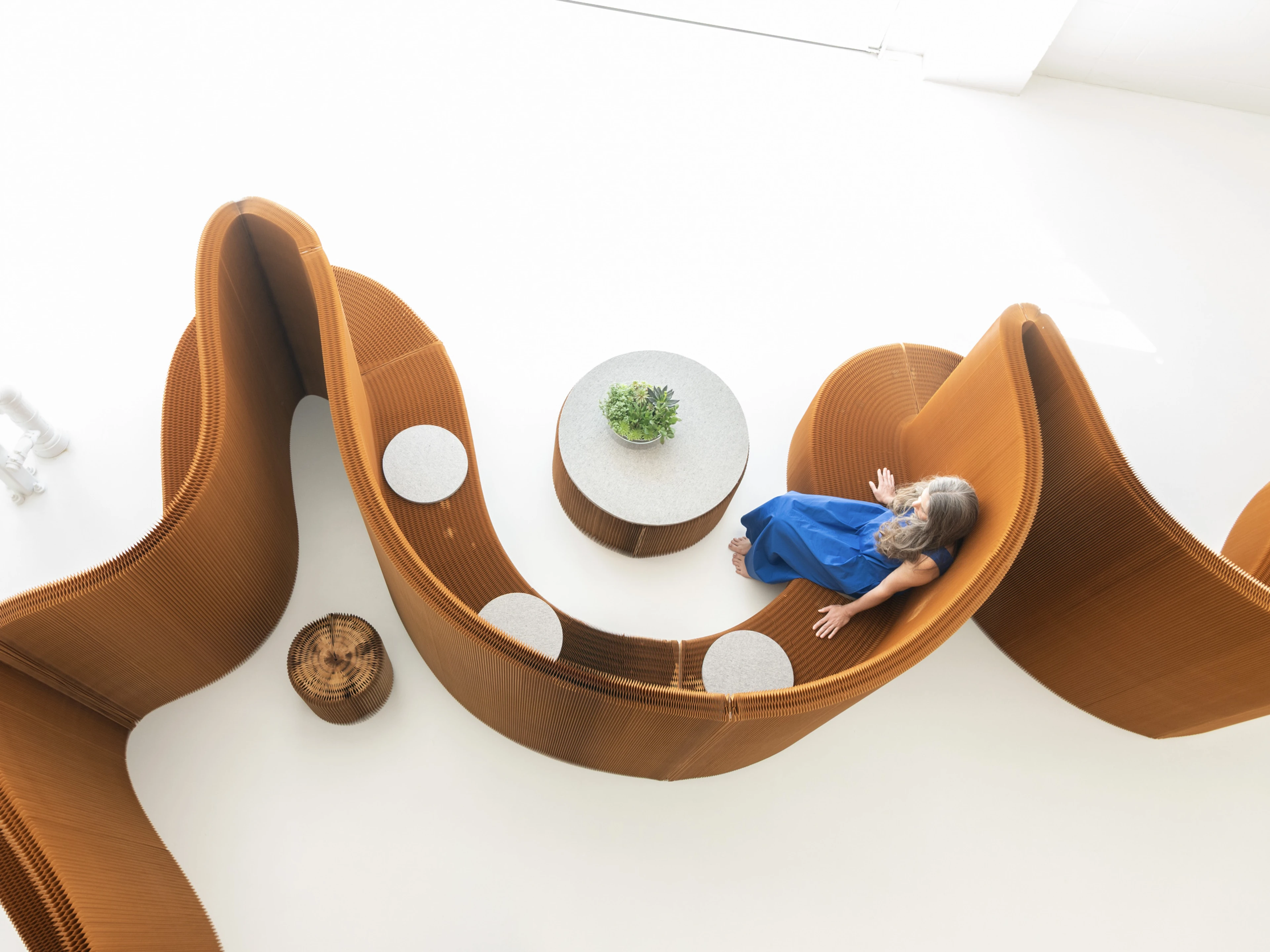 Pair softseating with benchwall as low tables, unifying space through flexible function, common materiality, and aesthetics.