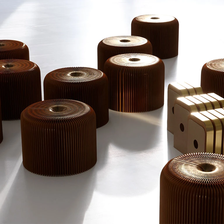a horde of gilded softseating fanning paper stools, in their open and compressed forms