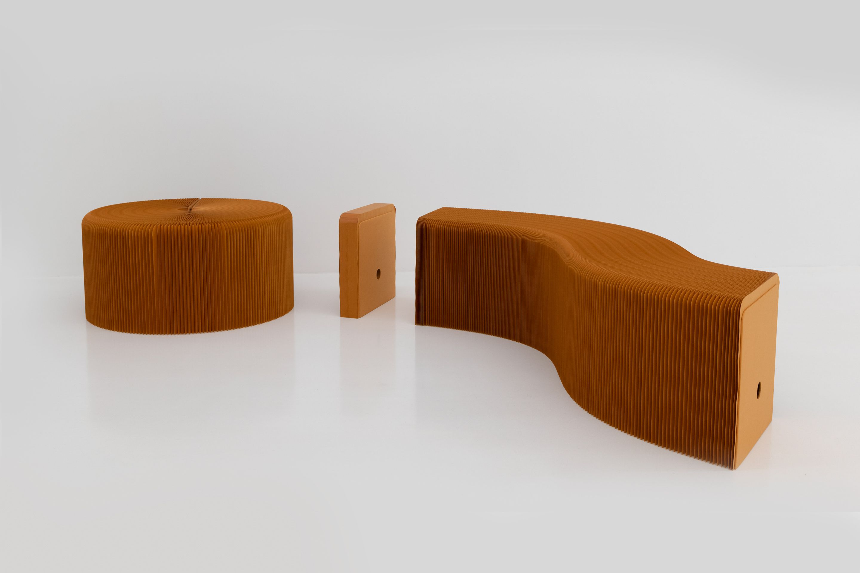 Depending on diameter, an individual element fans open into a paper stool or stretches into a bench.