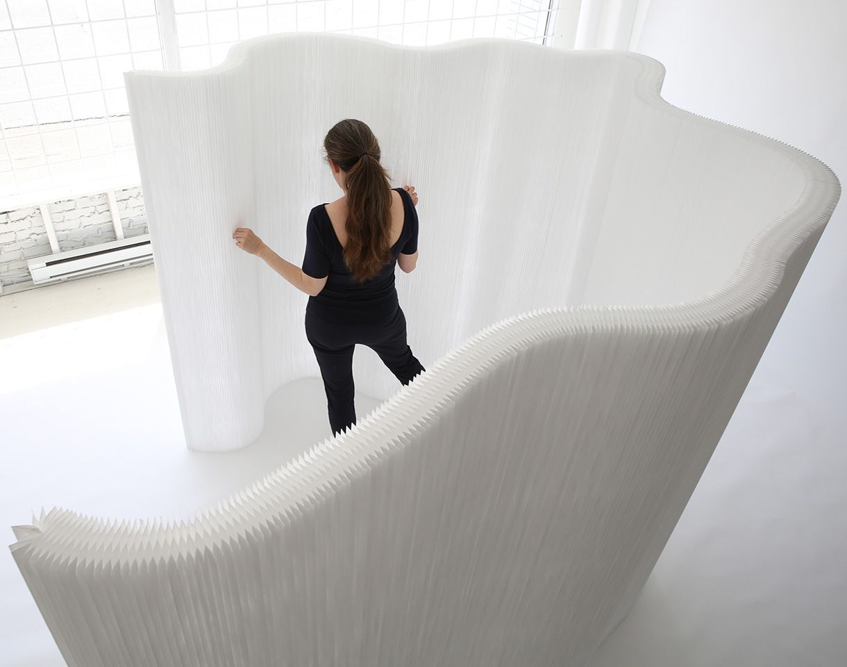 a woman arranges a white textile thinwall