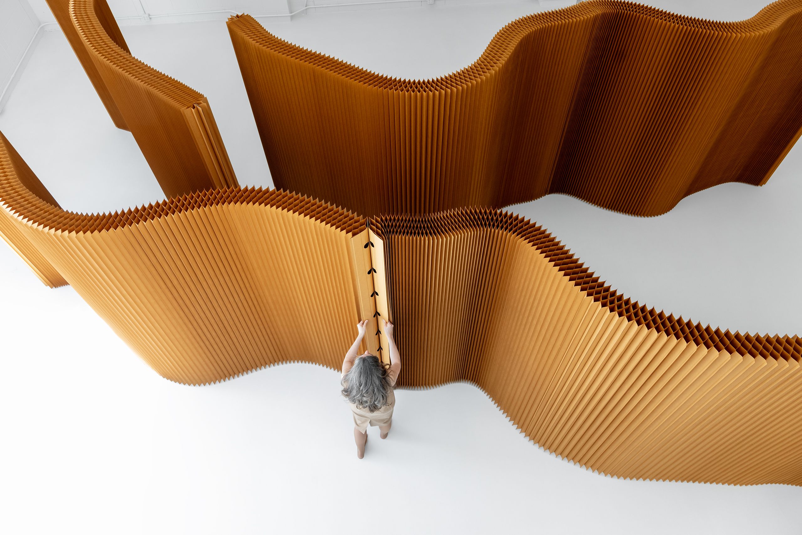 woman connecting two paper softwalls by their magnetic end panels