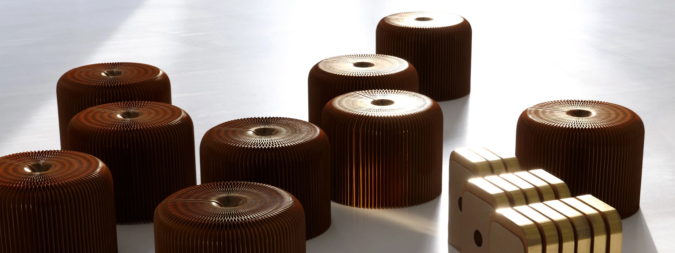 a horde of gilded softseating fanning paper stools, in their open and compressed forms