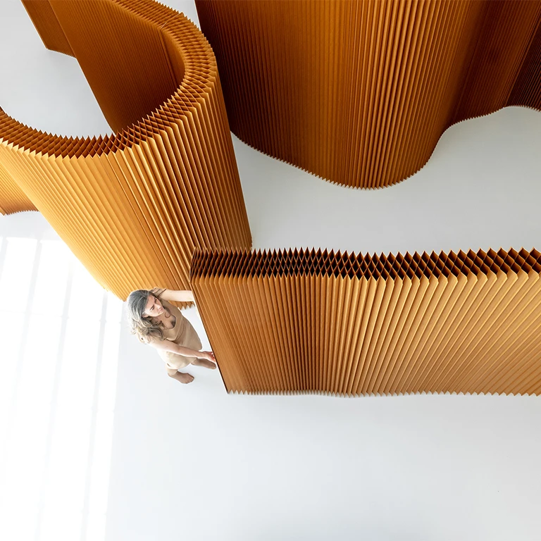 woman stretches flexible wall partition cardboard paper