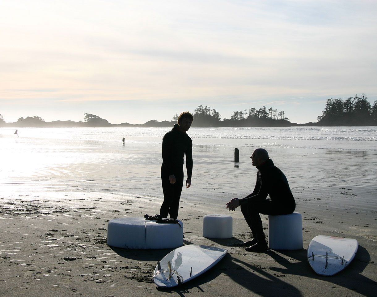 Surfers sit on softseating folding stools. Great beach furniture, this portable seating comes with carry tote. This is the water resistant textile version of original paper stool by molo.