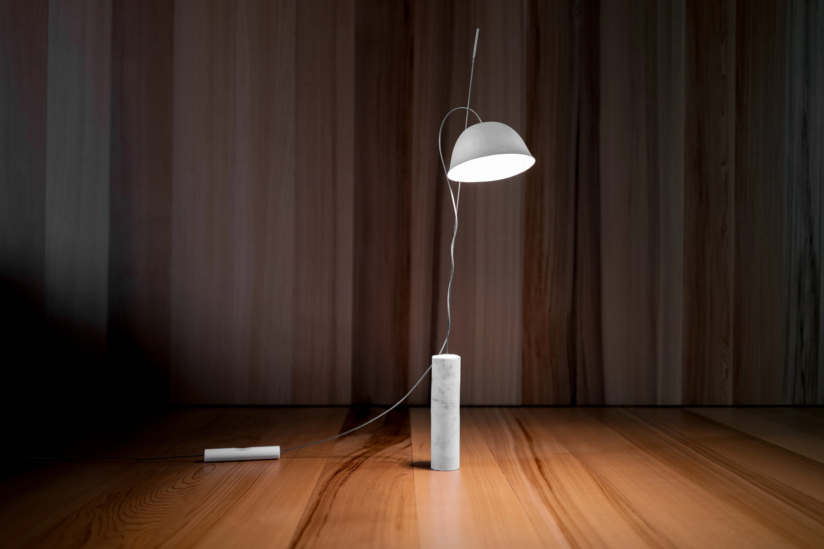 table lamp with paper lampshape and marble base in a wood room