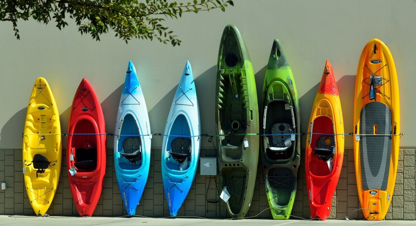 Kayaks and paddleboards racked in a row, ready to take out