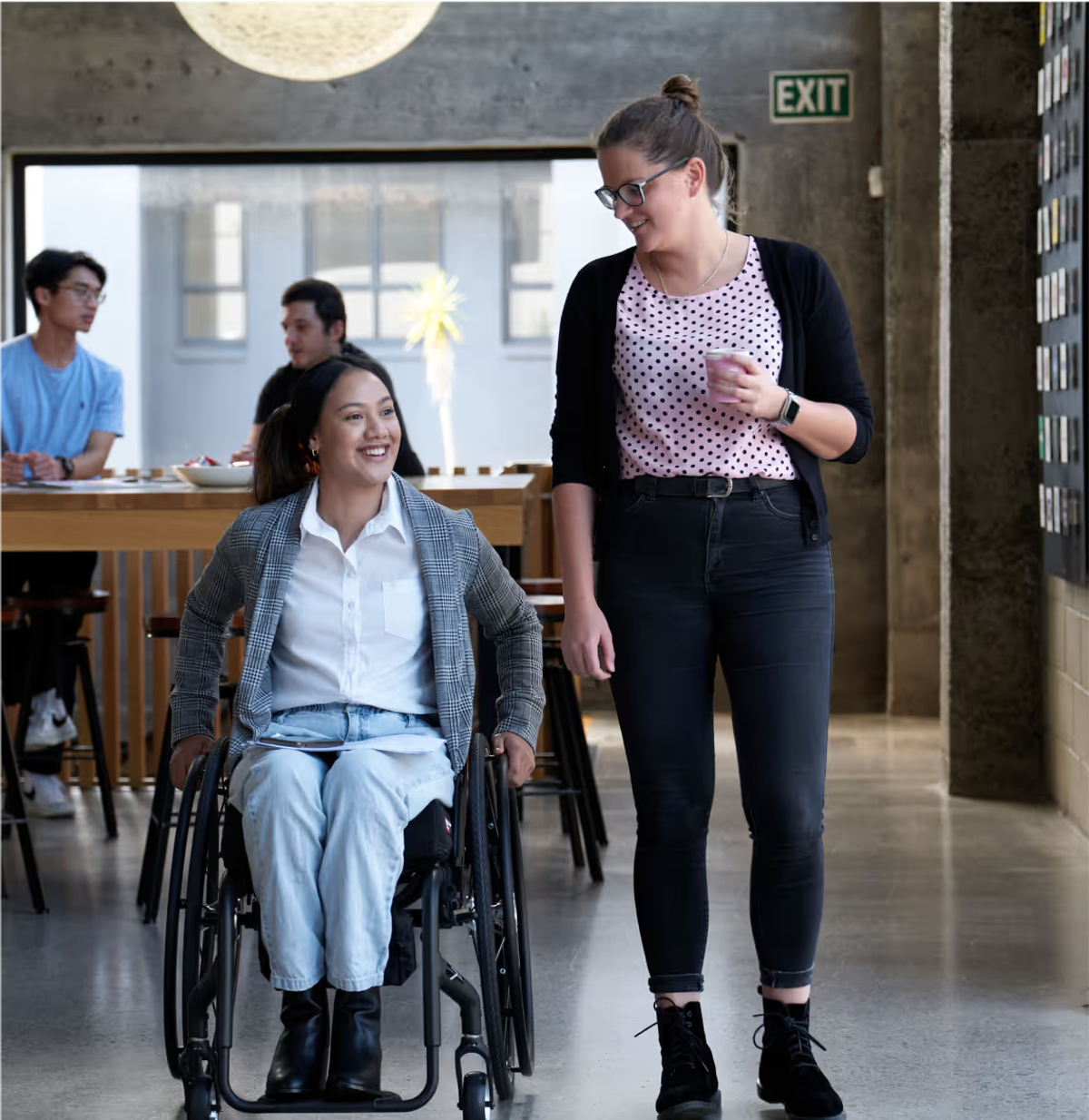 A wheelchair user and her colleague in a cafe. Credit: Medifab.