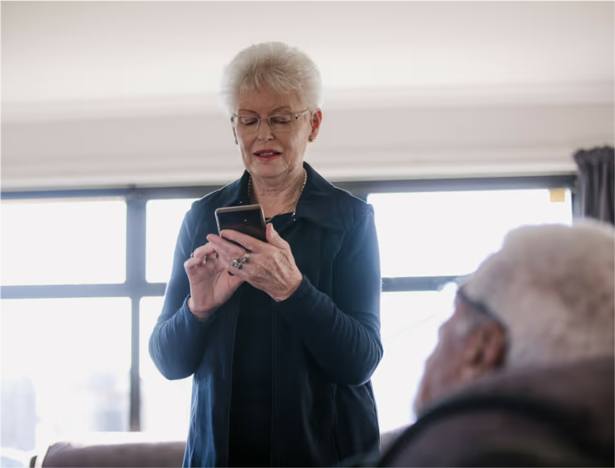 An older woman using her smartphone at home