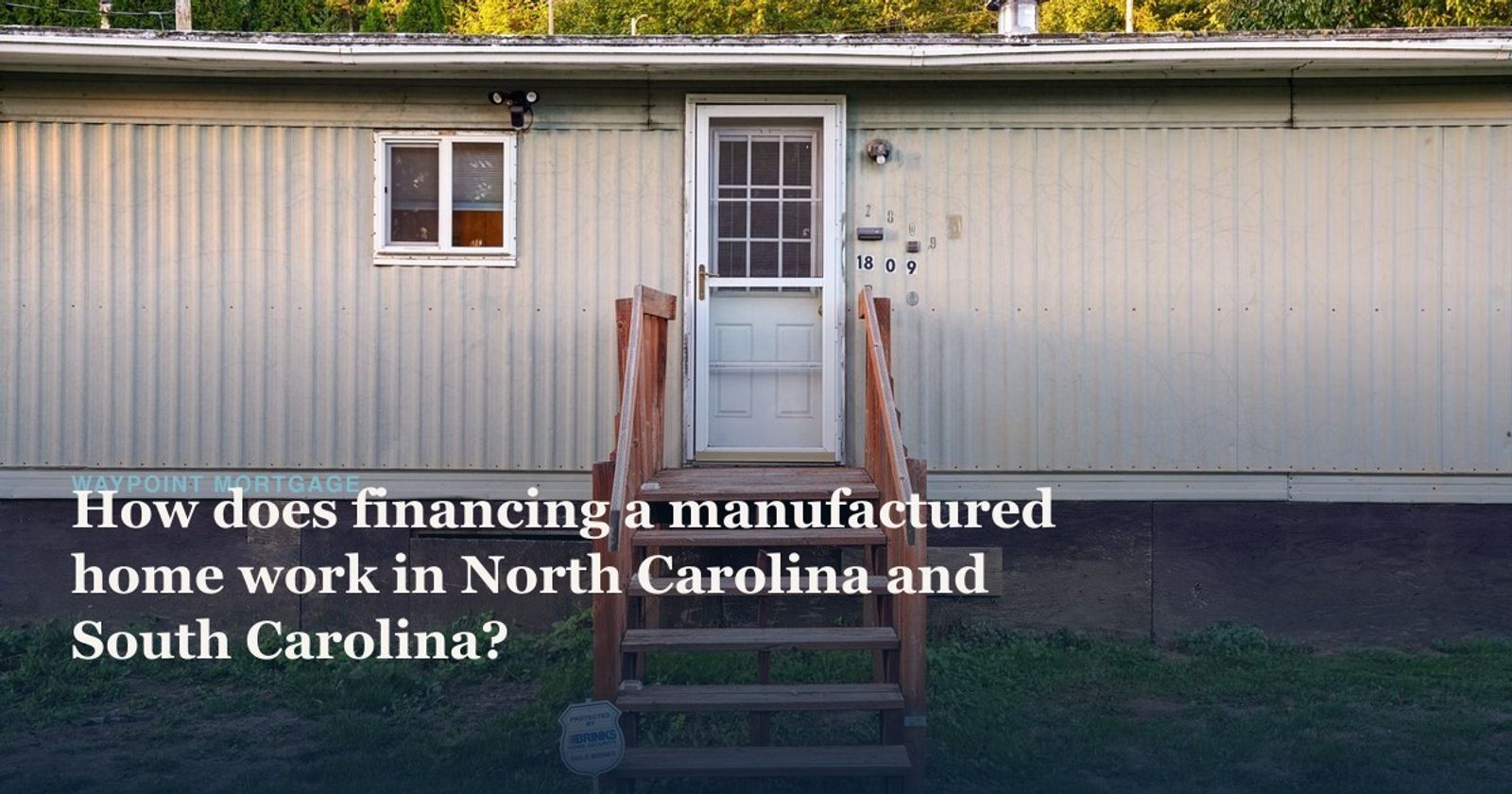 Exterior of a single-wide manufactured home with wooden entry steps