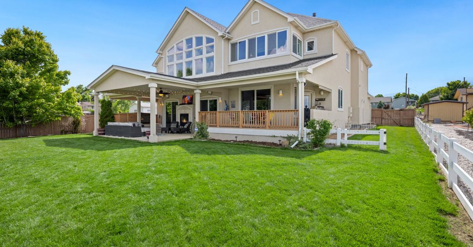 Beautiful two-story suburban house with a large green lawn and porch.