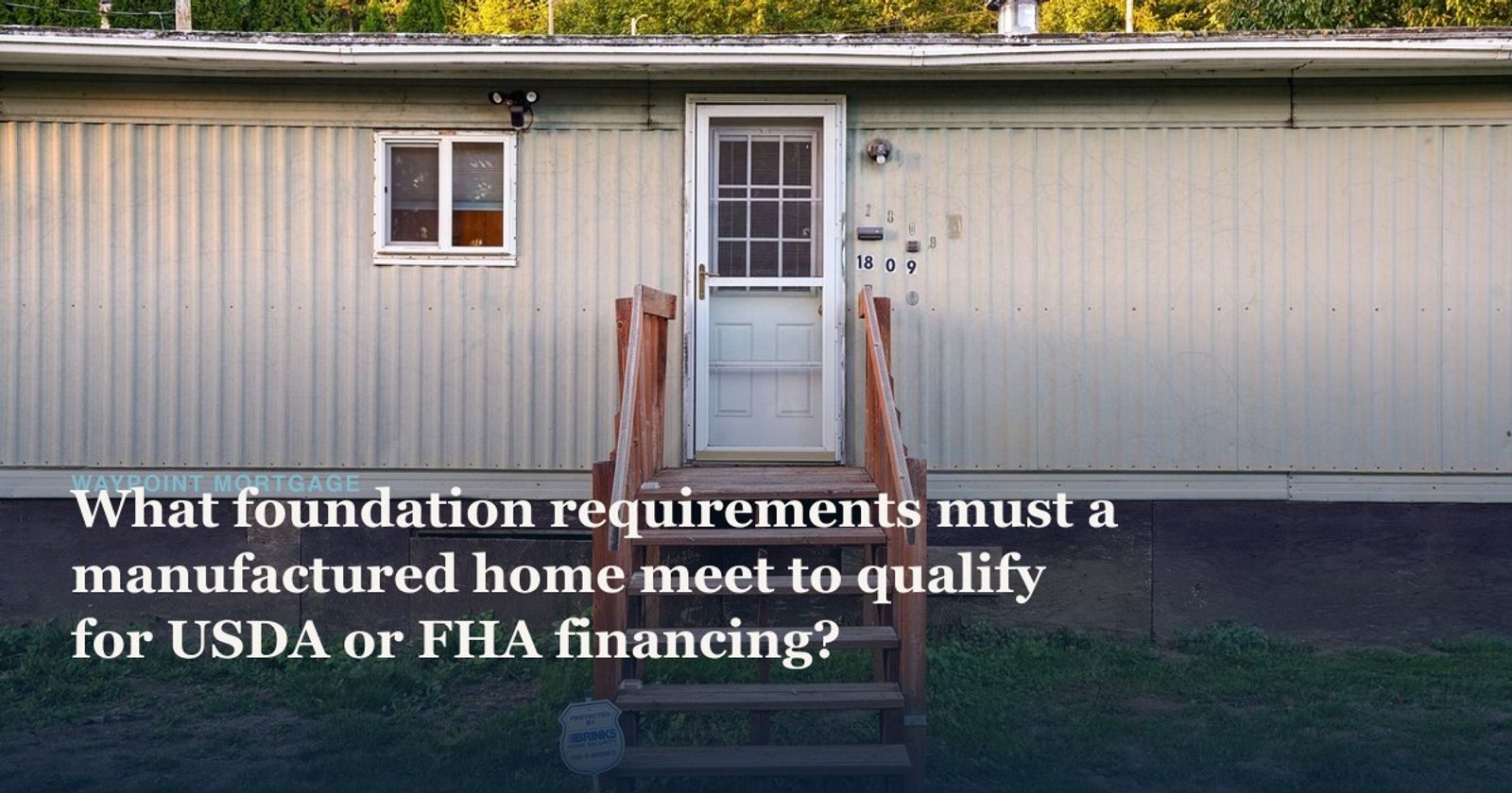 Exterior of a single-wide manufactured home with wooden entry steps