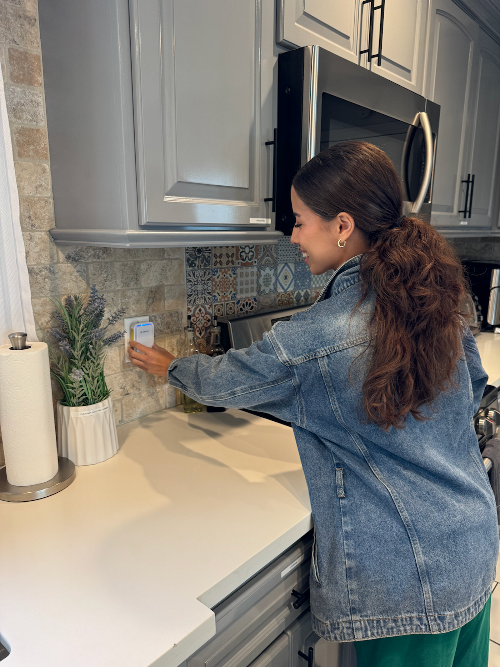 Woman plugging a Clarifion air ionizer into a kitchen wall outlet